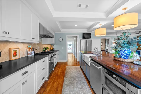 a large kitchen with stainless steel appliances granite countertop a lot of counter space and a sink