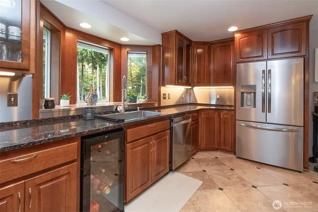 a kitchen with granite countertop a sink stainless steel appliances and cabinets