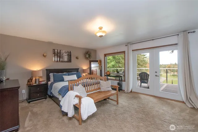 a spacious bedroom with a bed and glass walk in closet