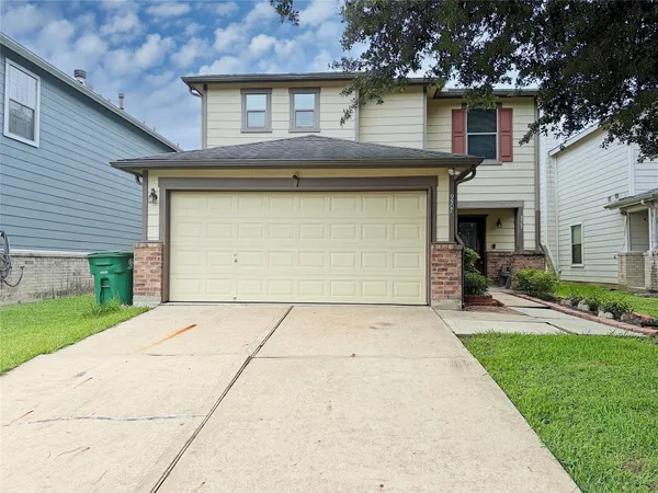 a front view of a house with a yard and garage