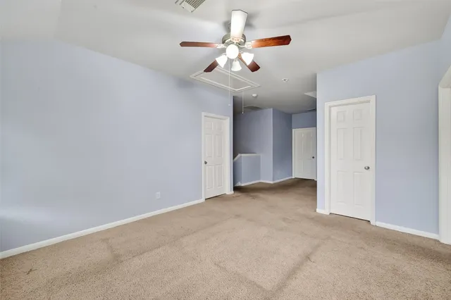 wooden floor in an empty room with a chandelier fan