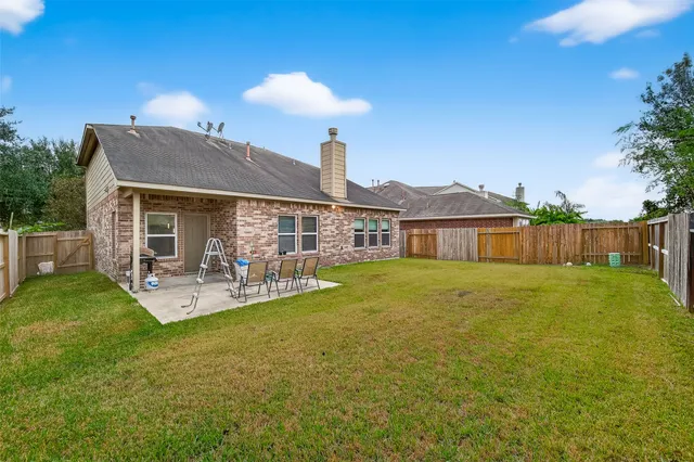 a front view of house with yard barbeque and outdoor seating