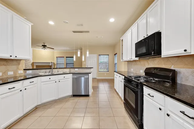 a large kitchen with stainless steel appliances granite countertop a stove top oven a sink dishwasher and a microwave oven on the blue kitchen countertops
