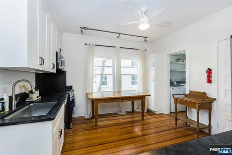 a kitchen with granite countertop a sink cabinets and wooden floor