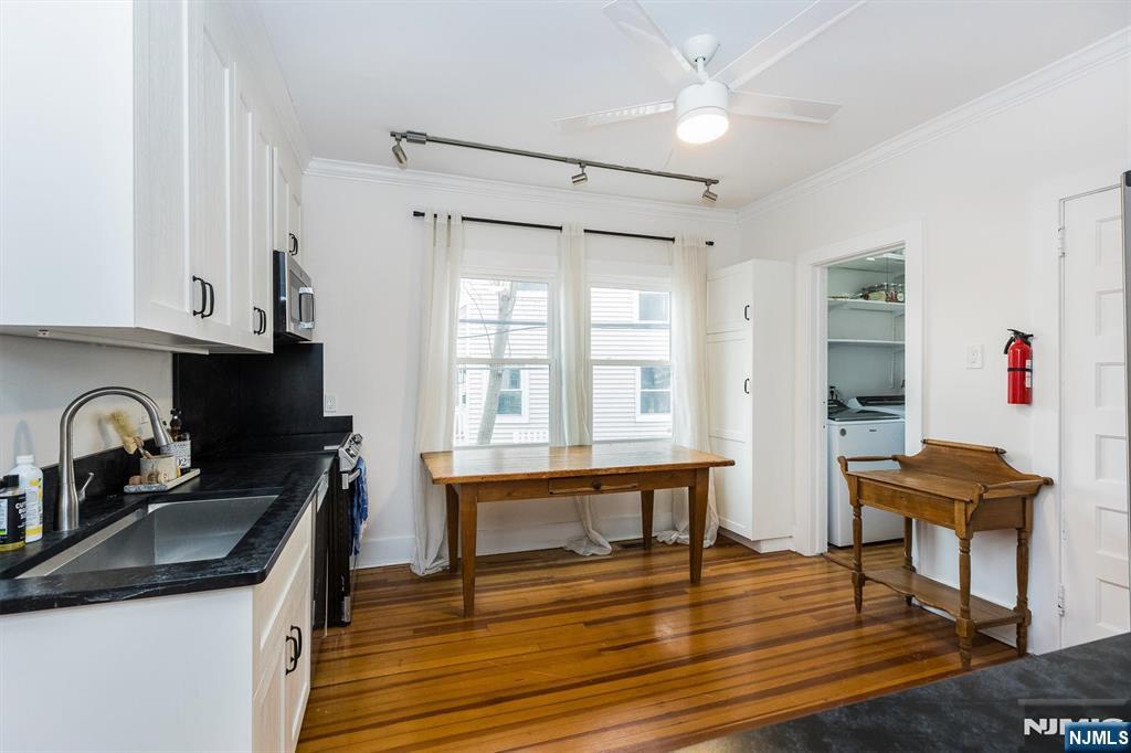 a kitchen with granite countertop a sink cabinets and wooden floor