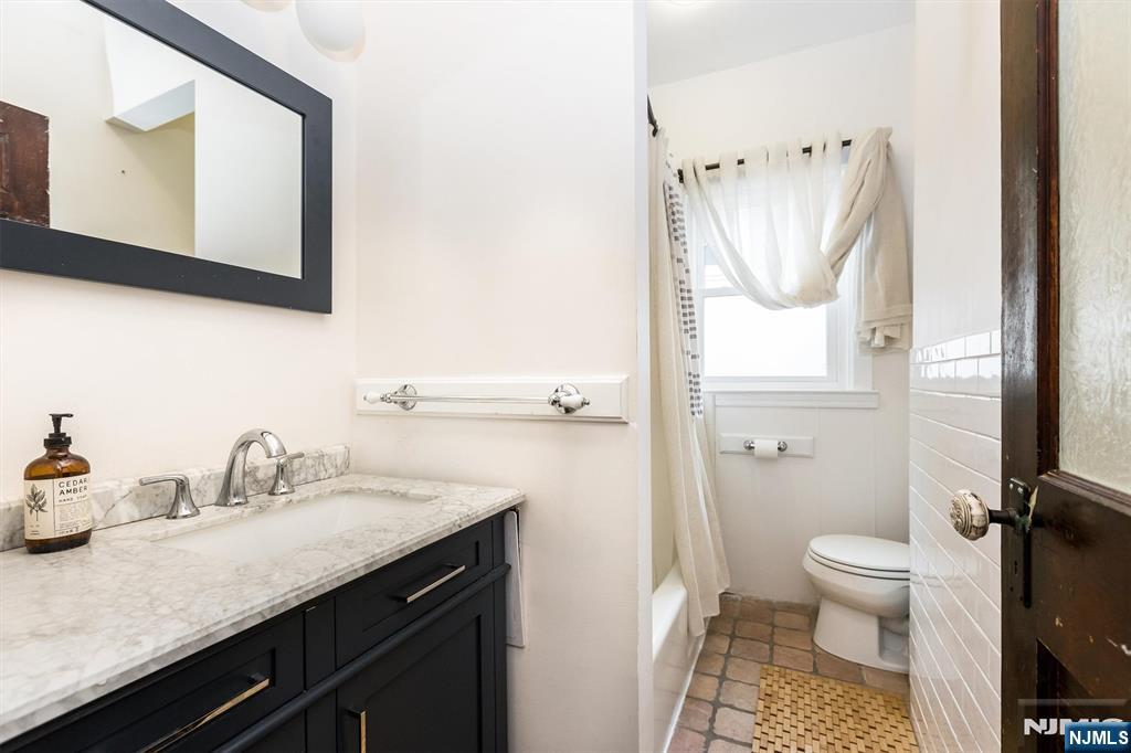 56 Walnut Crescent, Unit 1 Montclair, NJ 07042 - Photo 14 of 18 a bathroom with a sink a toilet and a mirror