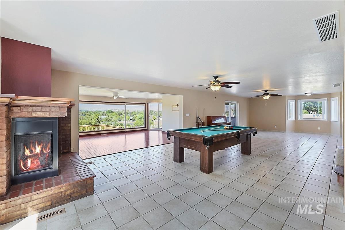 2804 West Sunrise Rim Road Boise, ID 83705 - Photo 15 of 50 Spacious interior featuring tile flooring, a brick fireplace, and multiple ceiling fans