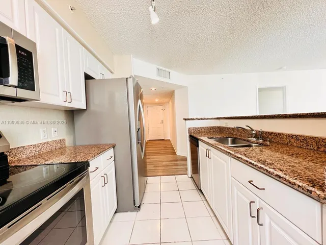 a kitchen with stainless steel appliances granite countertop a stove and a refrigerator