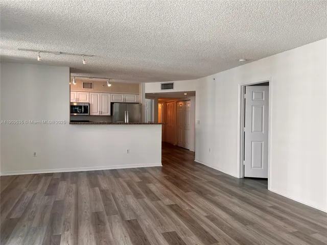 a view of a kitchen with wooden floor and electronic appliances