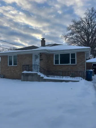 a front view of house with yard and trees in the background