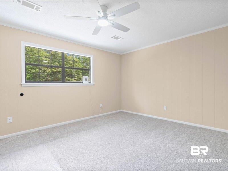 3160 Old Castleberry Road Brewton, AL 36426 - Photo 17 of 36 Room featuring neutral wall paneling, light gray carpeting, and a white ceiling fan with integrated lighting