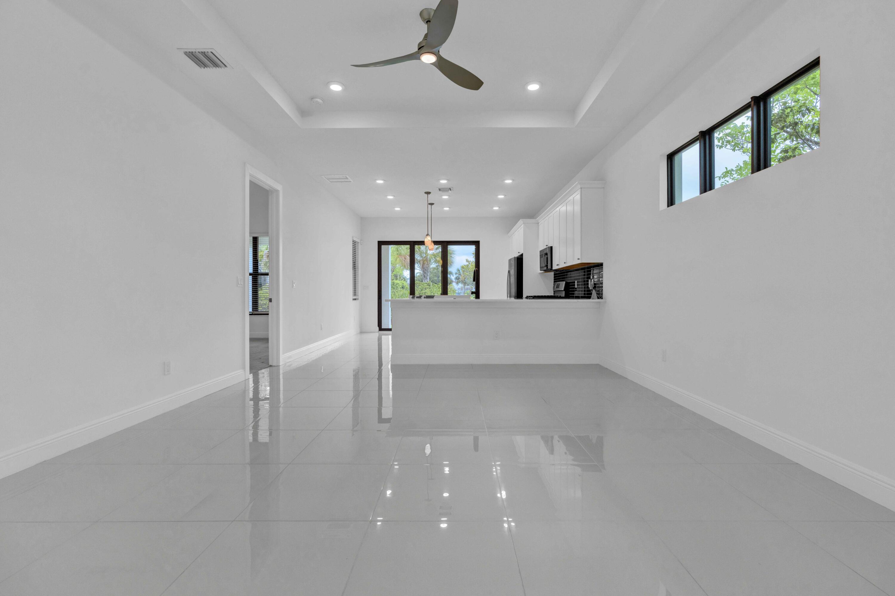 5501 Santa Rosa Lane Westlake, FL 33470 - Photo 5 of 31 an empty room with a kitchen and windows