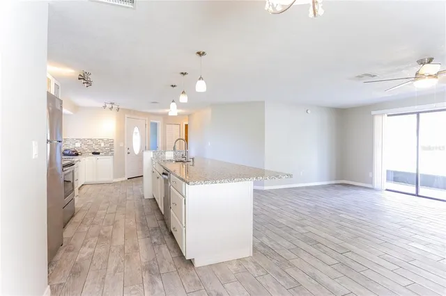 a large kitchen with a wooden floor and a large window
