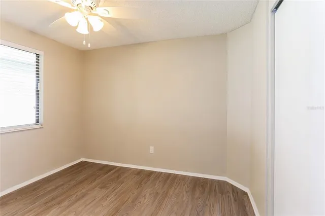 an empty room with a window and wooden floor