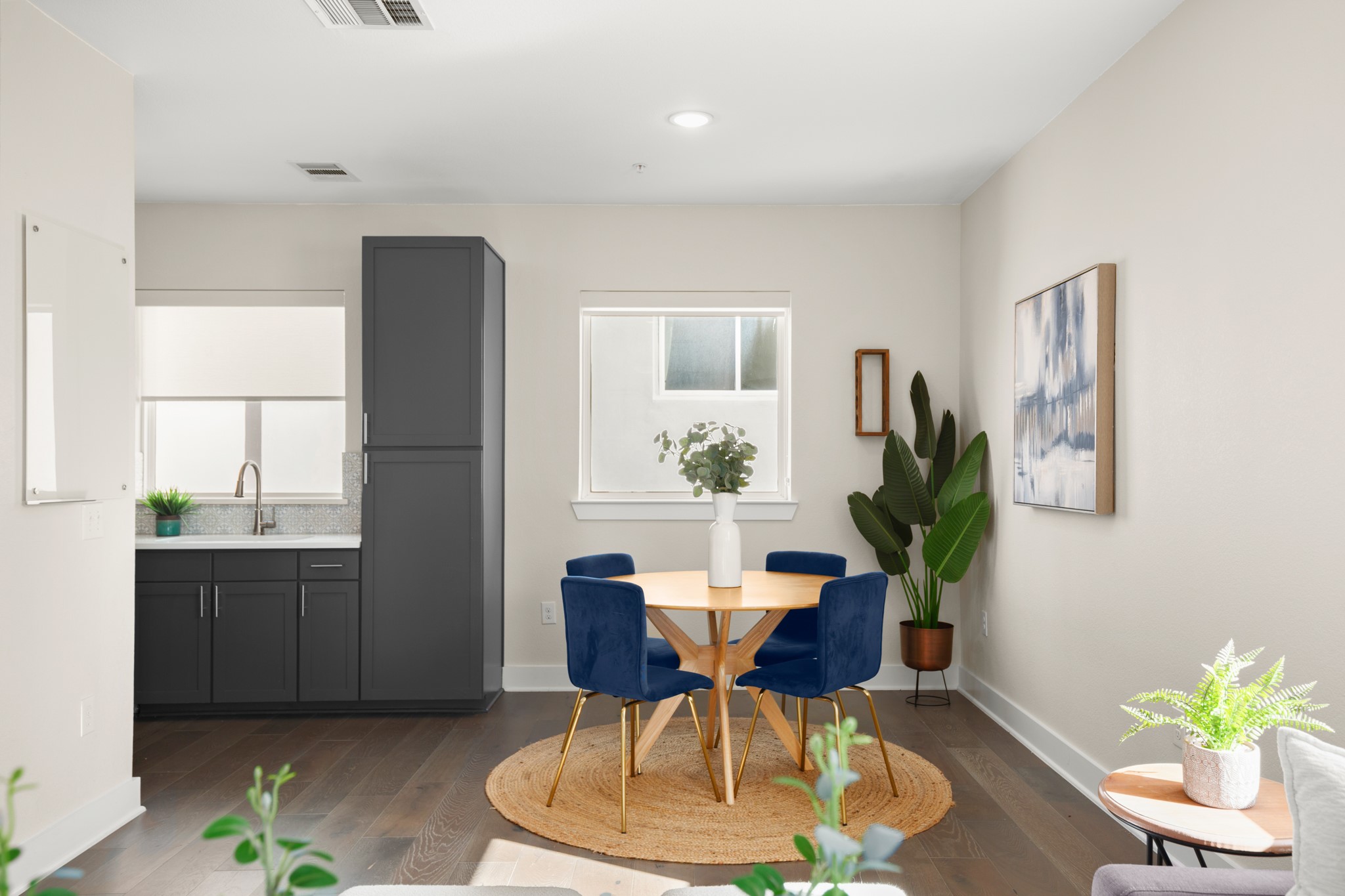 2827 Manor Road, Unit 3105 Austin, TX 78722 - Photo 13 of 26 a dining room with furniture two potted plants and wooden floor