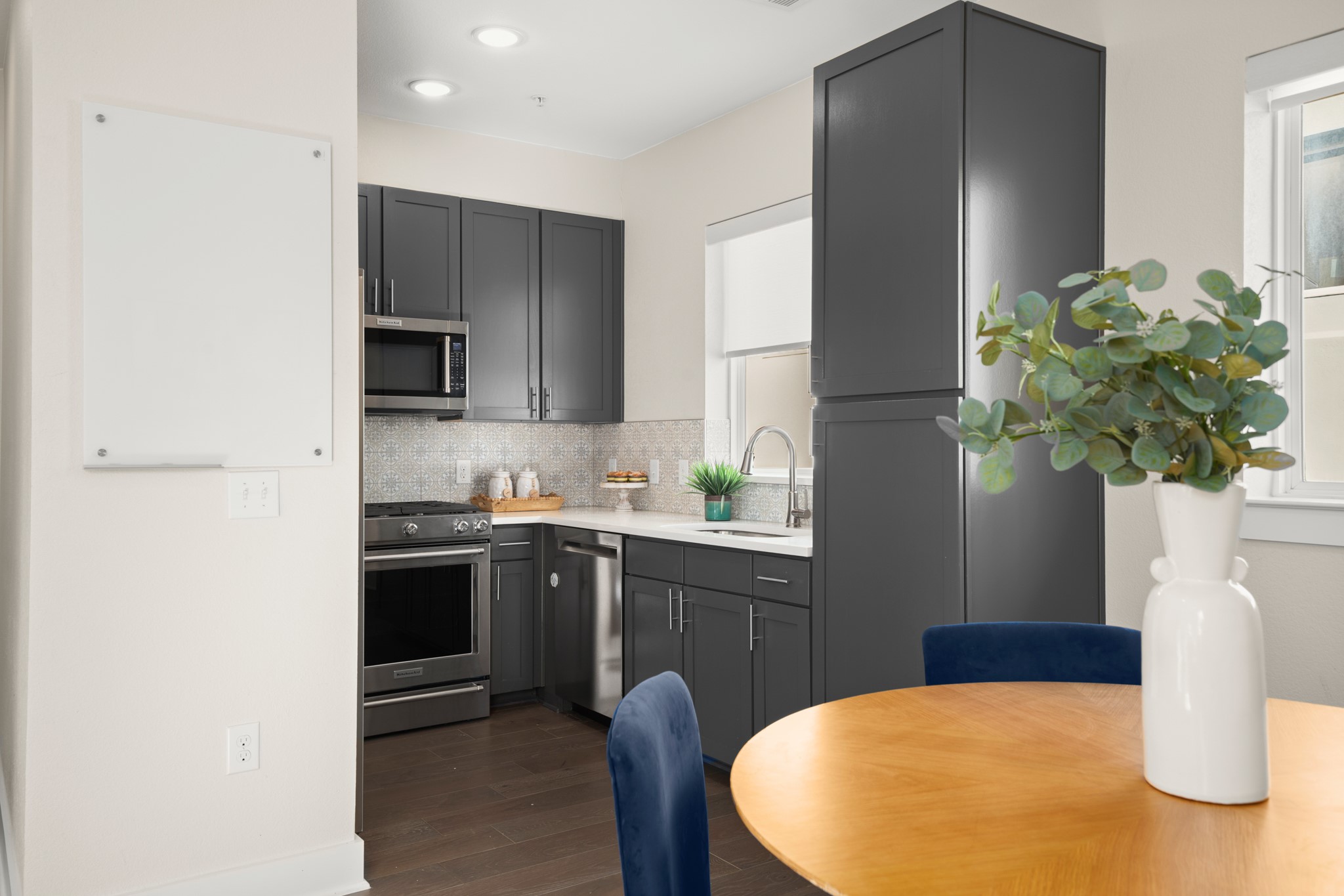 2827 Manor Road, Unit 3105 Austin, TX 78722 - Photo 15 of 26 a kitchen with stainless steel appliances kitchen island granite countertop a refrigerator a stove a sink a dining table and chairs