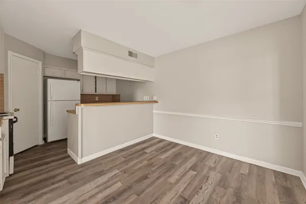 a view of a kitchen with wooden floor and electronic appliances