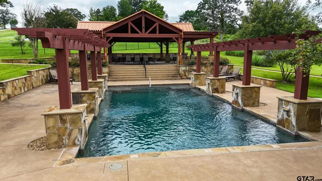 a view of a patio with table and chairs potted plants and large tree
