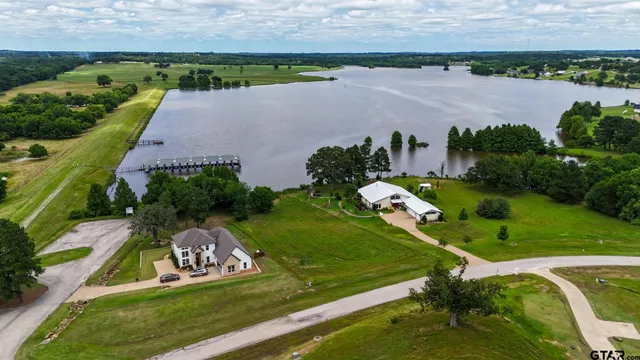 an aerial view of a golf course with a lake view