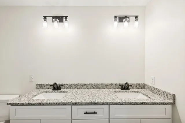 a bathroom with a granite countertop sink and vanity