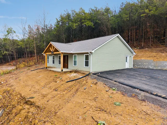 a view of house with backyard and trees around