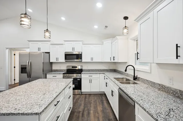 a kitchen with stainless steel appliances granite countertop a sink stove and refrigerator
