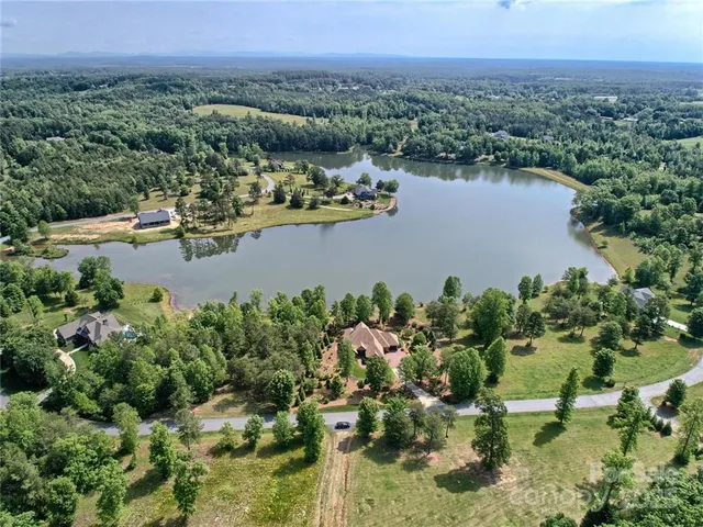 an aerial view of a house with a yard and lake view