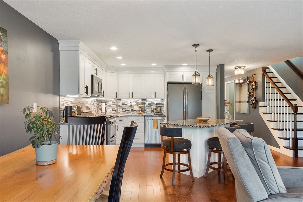 7 Green Briar Road, Unit 7 Fitchburg, MA 01420 - Photo 11 of 34 a kitchen with stainless steel appliances granite countertop a dining table chairs wooden floors and a view of kitchen