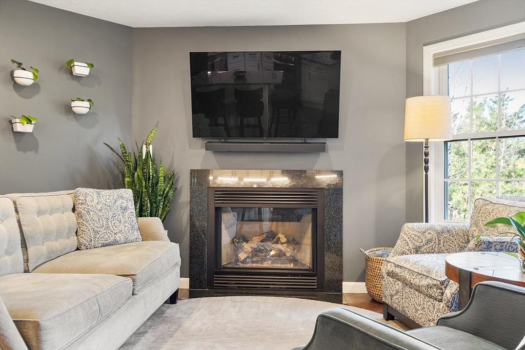 7 Green Briar Road, Unit 7 Fitchburg, MA 01420 - Photo 15 of 34 a living room with furniture a fireplace and a flat screen tv