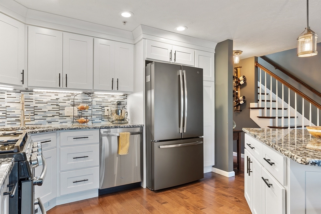 7 Green Briar Road, Unit 7 Fitchburg, MA 01420 - Photo 6 of 34 a kitchen with granite countertop a refrigerator a sink and white cabinets