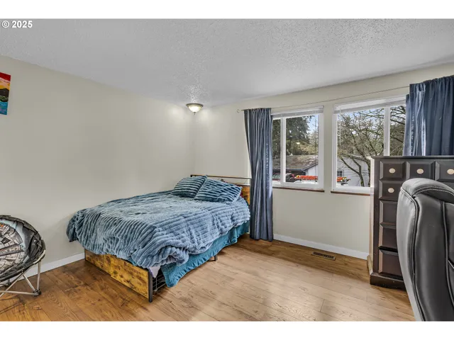 a bedroom with a bed next to a window