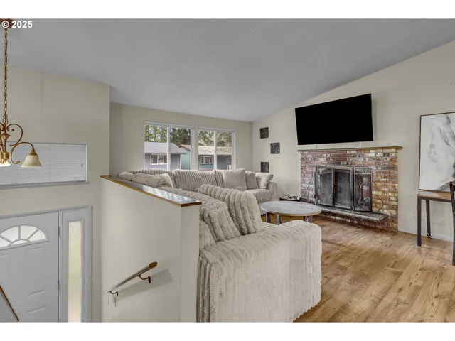 a living room with furniture a flat screen tv and a fireplace