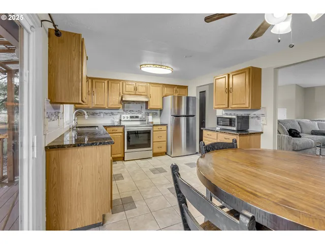 a kitchen with stainless steel appliances granite countertop a sink a stove counter space and cabinets