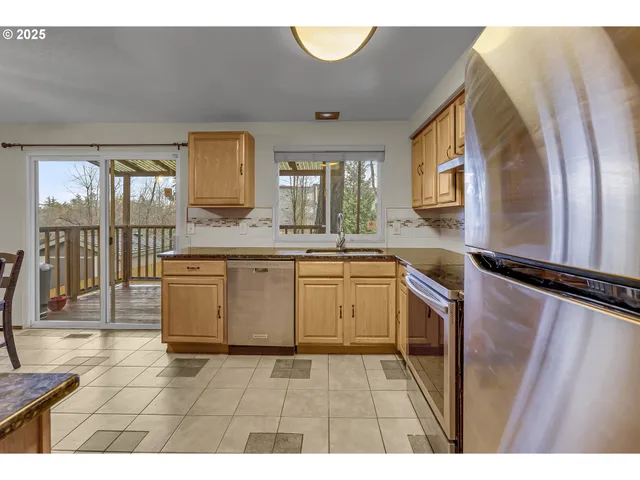 a large kitchen with a sink and dishwasher a stove with wooden floor