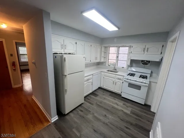 a kitchen with white cabinets and white appliances