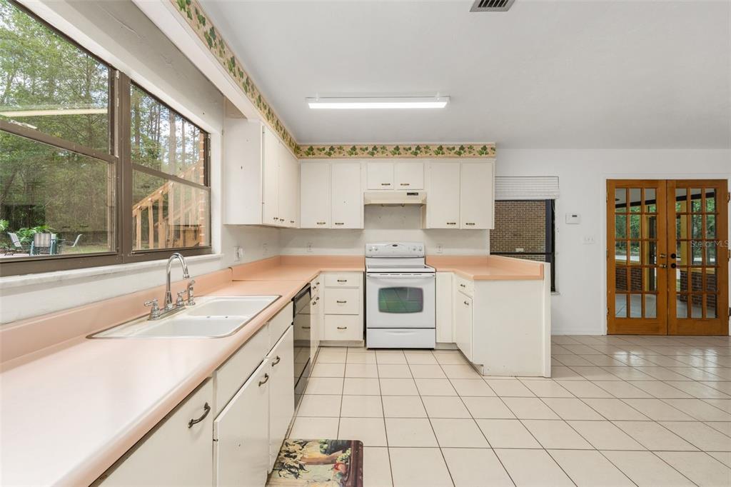 4703 Northwest 124th Street Gainesville, FL 32606 - Photo 23 of 55 a kitchen with a sink stove and cabinets