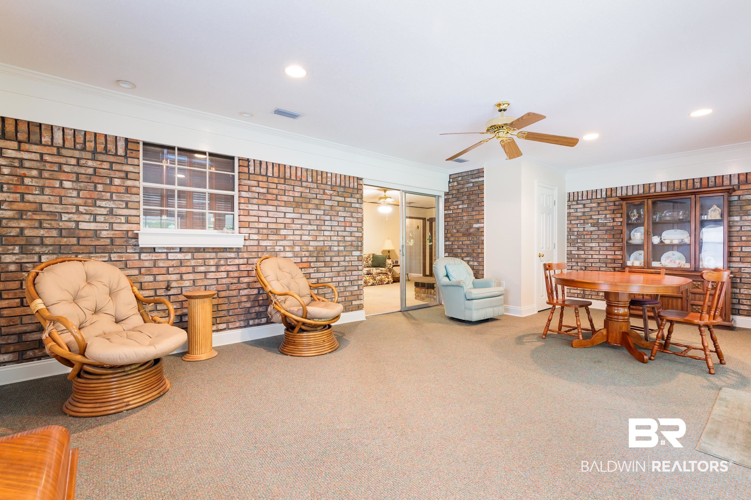 1367 Spring Valley Court Mobile, AL 36693 - Photo 10 of 29 Spacious room featuring exposed brick walls, soft carpet flooring, recessed lighting, a ceiling fan, and sliding glass doors