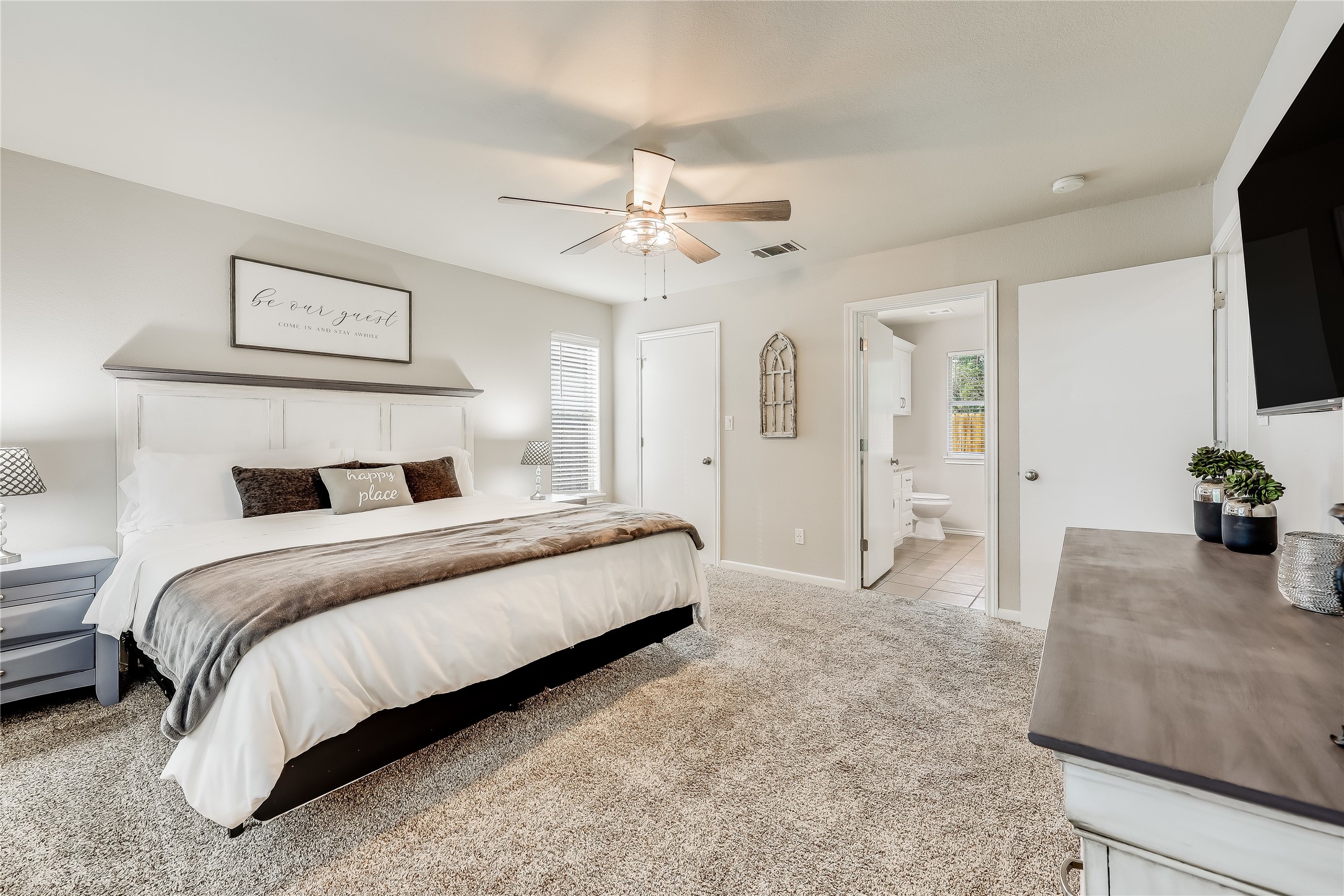 426 Summit Ridge Drive North Point Venture, TX 78645 - Photo 15 of 28 Bedroom featuring light colored carpet, ceiling fan, and ensuite bathroom