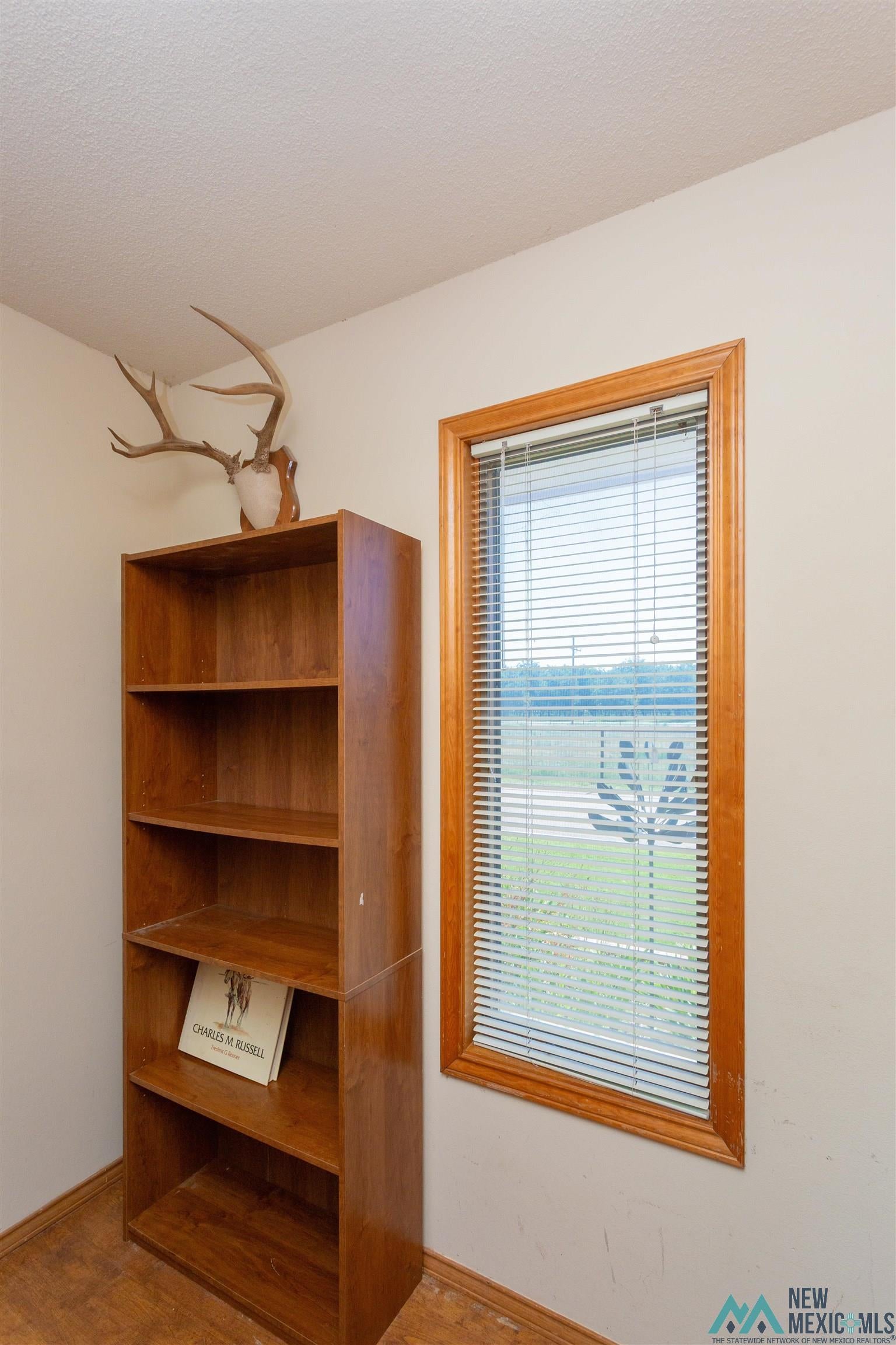 2012 South Haldeman Road Artesia, NM 88210 - Photo 44 of 96 Wood-finish flooring paired with a rectangular window featuring blinds and a natural wood trim