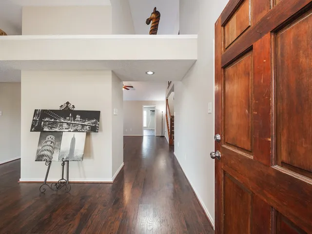a view of a hallway with wooden floor and staircase