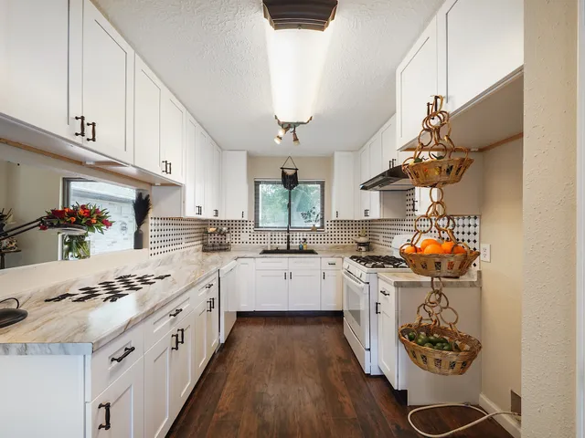 a kitchen with stainless steel appliances kitchen island granite countertop a lot of counter space and wooden floors