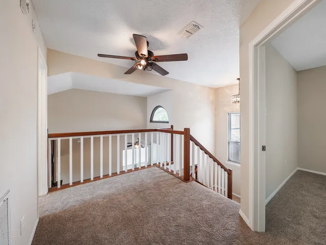 a view of staircase with a ceiling fan