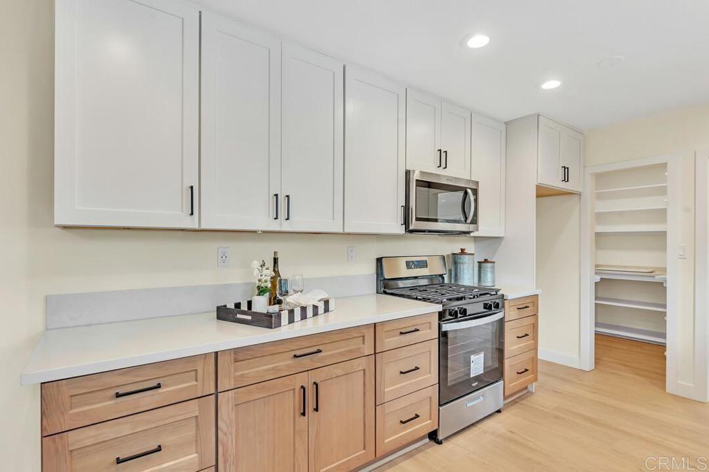 1165 Oak Drive Vista, CA 92084 - Photo 20 of 33 a kitchen with granite countertop white cabinets stainless steel appliances and a sink