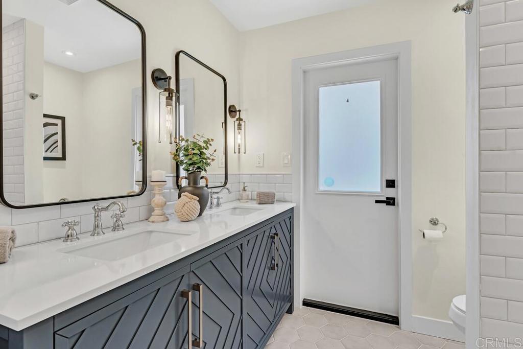 1165 Oak Drive Vista, CA 92084 - Photo 33 of 33 a bathroom with double vanity sink and a mirror