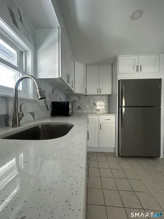 a kitchen with a sink a refrigerator and cabinets