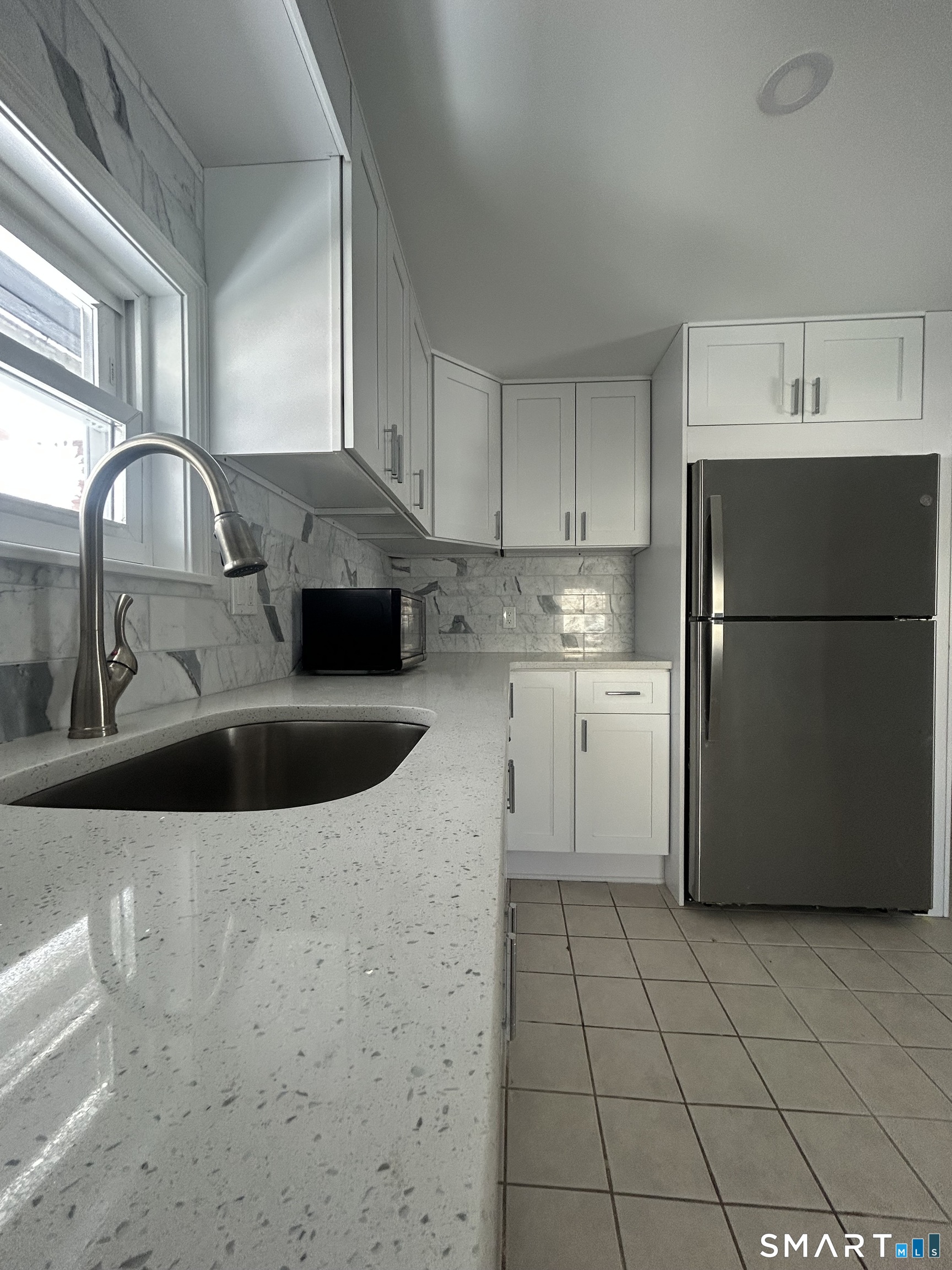 54 Forest Street, Unit 2 Torrington, CT 06790 - Photo 12 of 36 a kitchen with a sink a refrigerator and cabinets