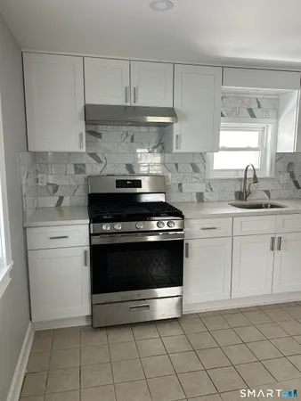 a kitchen with granite countertop white cabinets and appliances