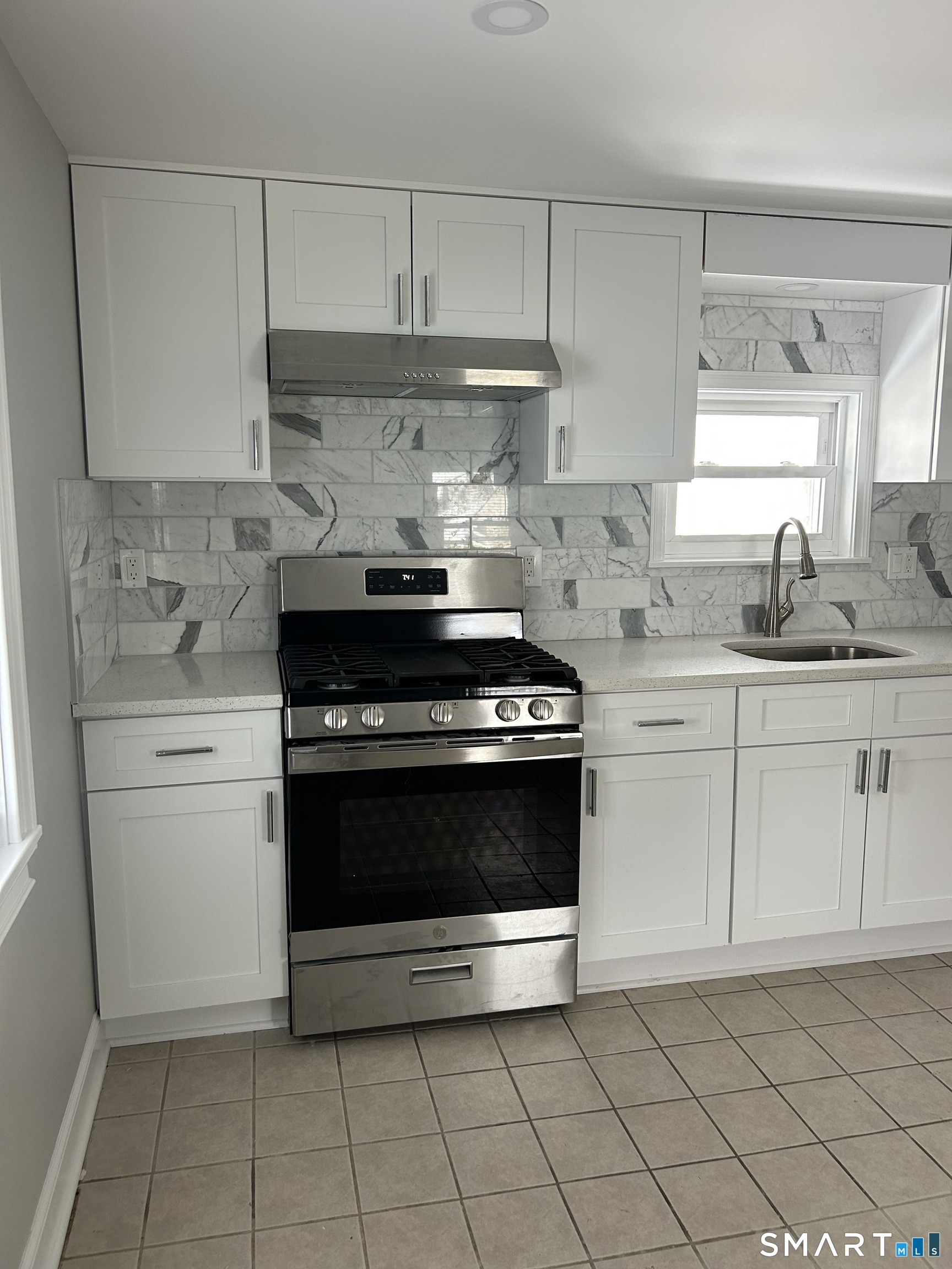 54 Forest Street, Unit 2 Torrington, CT 06790 - Photo 14 of 36 a kitchen with granite countertop white cabinets and appliances