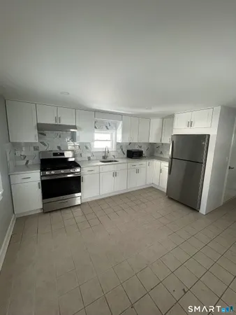 a kitchen with a refrigerator and a stove