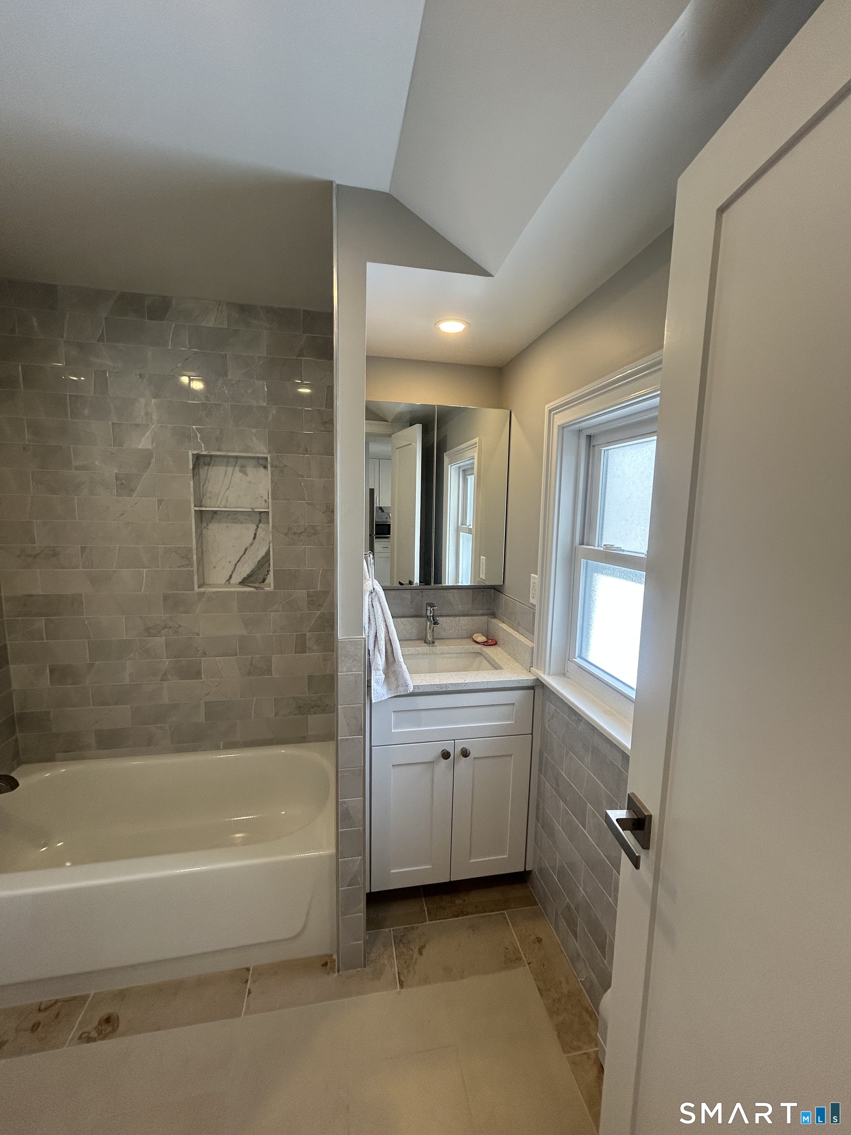 54 Forest Street, Unit 2 Torrington, CT 06790 - Photo 18 of 36 a bathroom with a granite countertop sink mirror bathtub and next to a window